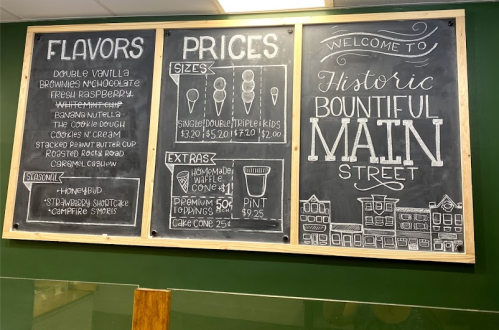 Chalkboard menu displaying ice cream flavors, prices, sizes, and extras at Historic Bountiful Main Street.