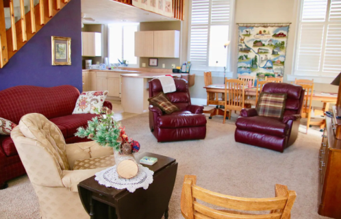Cozy living area with plush seating, a dining table, and a kitchen in a bright, inviting space.