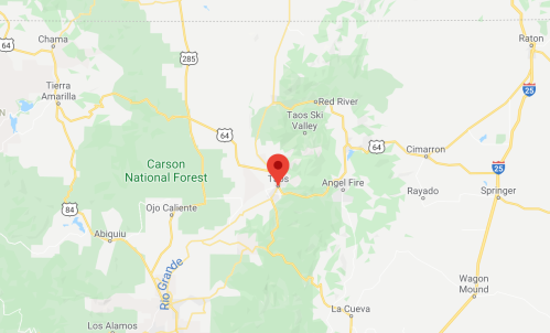 Map showing the location of Taos, New Mexico, marked with a red pin amidst surrounding forests and highways.