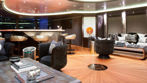 Luxurious interior of a modern lounge with stylish furniture, a bar, and elegant decor. Warm lighting enhances the ambiance.