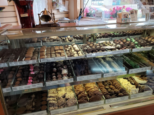 A display case filled with a variety of chocolates and confections, showcasing an assortment of shapes and colors.