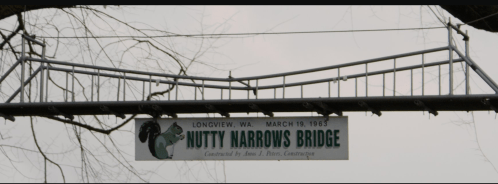 Sign for Nutty Narrows Bridge in Longview, WA, dated March 19, 1963, featuring a squirrel graphic.