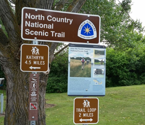 Sign for the North Country National Scenic Trail, featuring distance markers and information about hiking the trail.