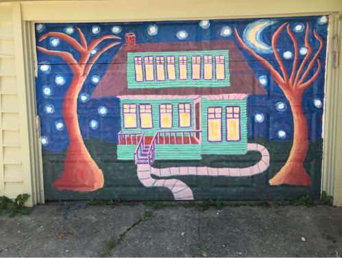 A colorful mural of a house with trees and stars, painted on a garage door.