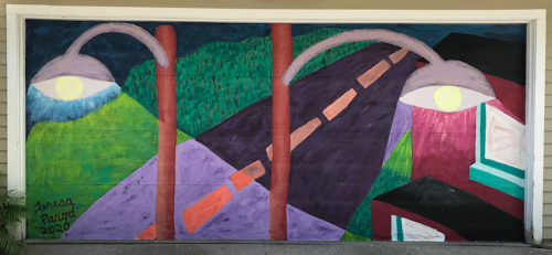 Colorful mural featuring abstract shapes, streetlights, and a winding road on a garage door.