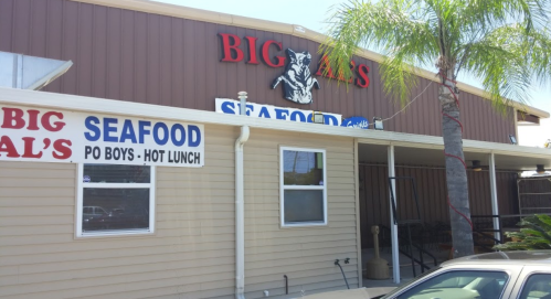 Exterior of Big Al's Seafood restaurant, featuring a sign and palm tree, with a casual dining atmosphere.