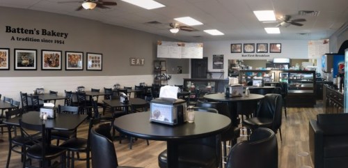 Interior of Batten's Bakery featuring tables, chairs, a counter, and a menu on the wall, creating a cozy dining atmosphere.