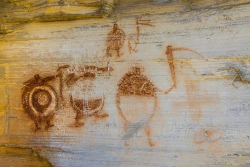 Ancient rock art featuring circular and abstract designs on a textured stone surface.