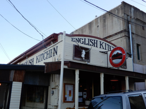Exterior of a restaurant named "English Kitchen," featuring a sign and decorative elements, with power lines overhead.