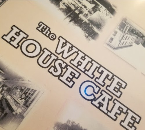 Text on a menu cover featuring "The White House Cafe" with black and white photos in the background.