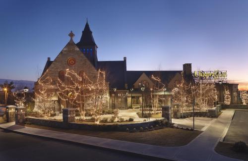 A beautifully lit stone building at dusk, featuring festive lights and a sign for "Chagrin Falls."