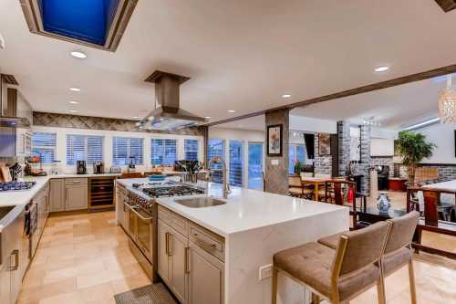 Modern kitchen with stainless steel appliances, a large island, and an open layout leading to a dining area.