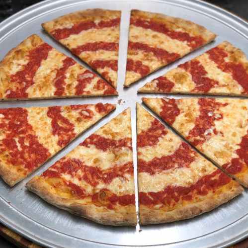 A round pizza sliced into eight pieces, topped with cheese and a rich tomato sauce.