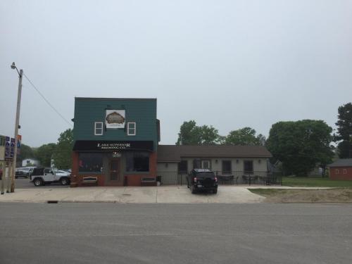 A two-story building with a green upper section and a red lower section, featuring a sign for Lake Superior Brewing Co.
