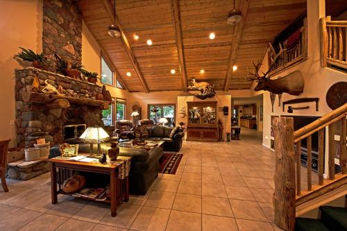 Cozy living room with stone fireplace, wooden beams, and rustic decor, featuring leather sofas and a staircase.