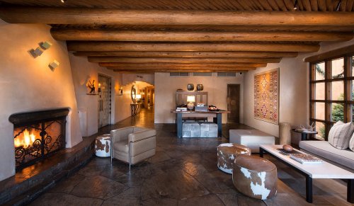Cozy interior with wooden beams, a fireplace, modern furniture, and warm lighting in a stylish living space.