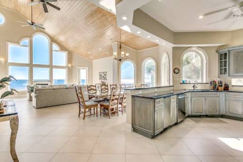 Bright, open-concept kitchen and dining area with large windows and coastal views, featuring modern cabinetry and a spacious layout.