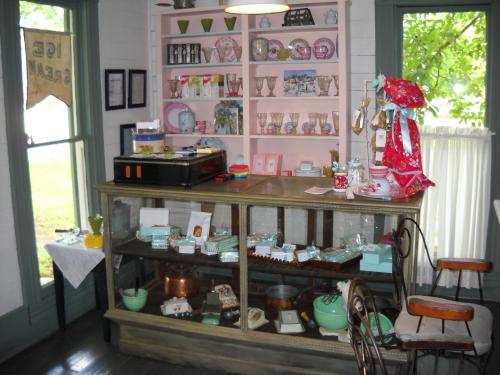 A cozy shop interior featuring a display case with various vintage items and a colorful shelf of collectibles.