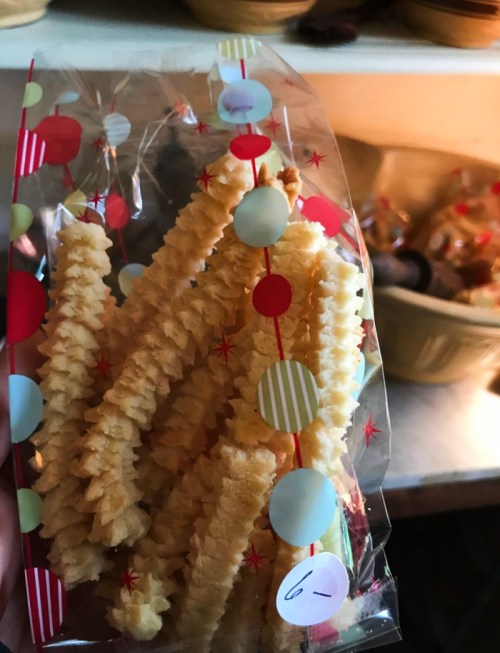 A clear bag filled with crinkle-cut potato snacks, decorated with colorful polka dots and a festive design.