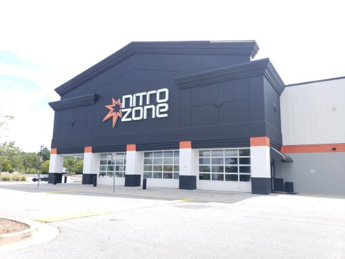 Exterior of a building with a large sign reading "Nitro Zone," featuring a modern design and large windows.
