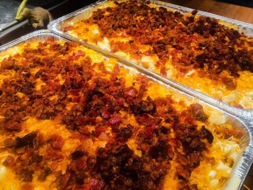 Two trays of baked macaroni and cheese topped with crispy bacon and golden brown breadcrumbs.