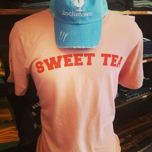 A peach-colored t-shirt with "SWEET TEA" printed in bold red letters, topped with a light blue cap.