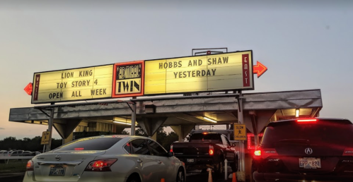 Drive-in movie theater marquee displaying "Lion King," "Toy Story 4," "Hobbs and Shaw," and "Yesterday." Open all week.