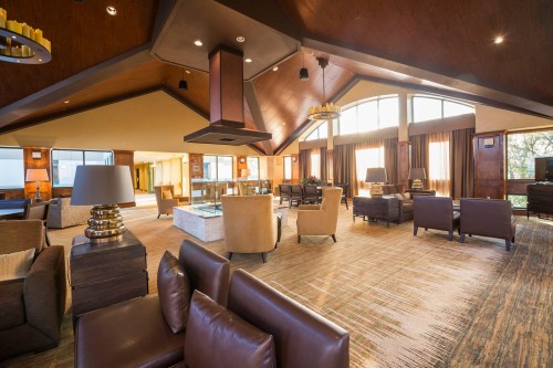 A spacious, modern lounge with large windows, comfortable seating, and stylish decor.
