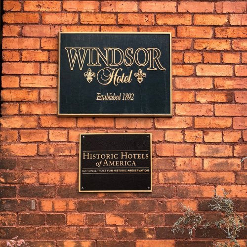 Signage for Windsor Hotel, established 1892, and Historic Hotels of America, on a brick wall.