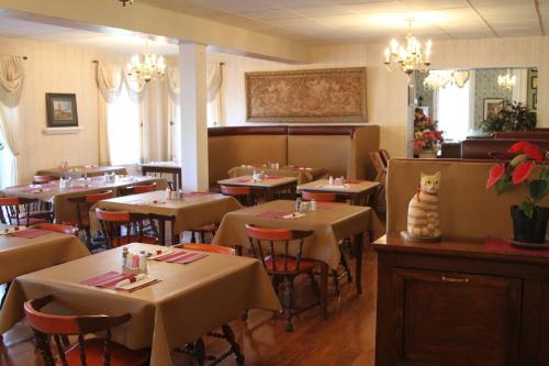 Cozy restaurant interior with tables set for dining, warm lighting, and decorative plants.