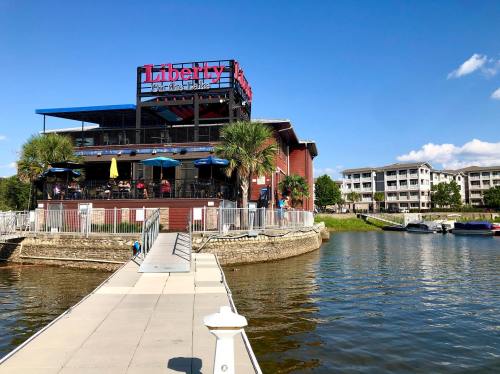 A waterfront restaurant named Liberty with outdoor seating, surrounded by palm trees and a clear blue sky.