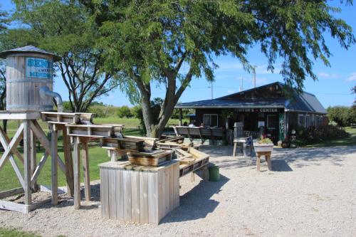 A visitor center surrounded by greenery, featuring a wooden water feature and outdoor seating.