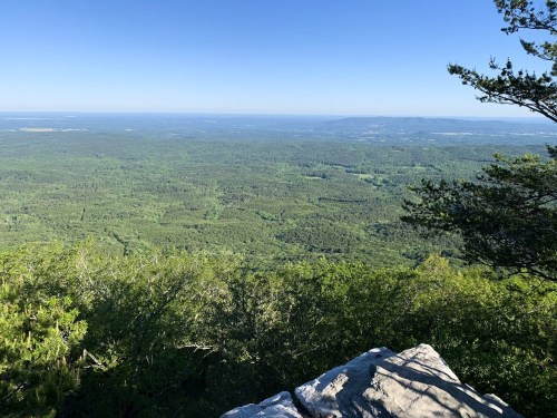 A panoramic view of lush green mountains and valleys under a clear blue sky.