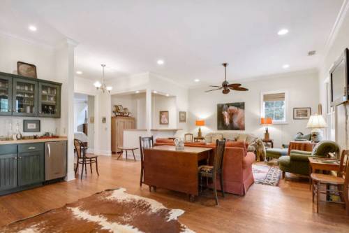 Cozy living space with a dining area, comfortable seating, and warm lighting, featuring wooden floors and decorative accents.
