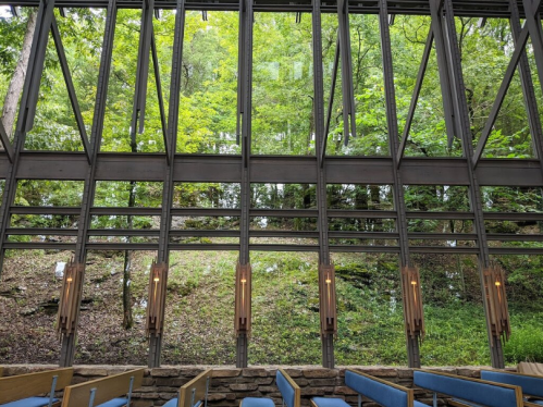 Interior of a modern building with large windows showcasing a lush green landscape outside.