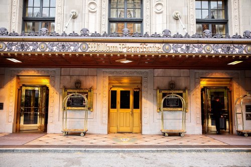 Entrance of the William Penn Hotel, featuring ornate architecture and golden doors.