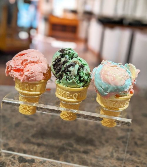 Three colorful ice cream scoops in waffle cones: pink, mint chocolate chip, and blue cotton candy.
