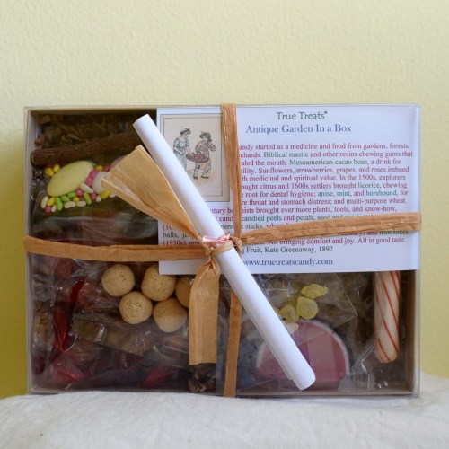 A gift box filled with assorted candies and a scroll, labeled "True Treats Antique Garden In A Box."