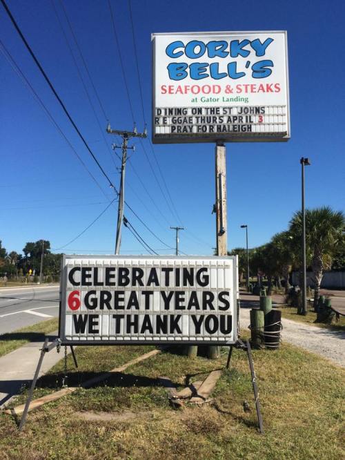 Sign for Corky Bell's Seafood & Steaks celebrating 6 great years, with a message of thanks and a note about a reggae event.