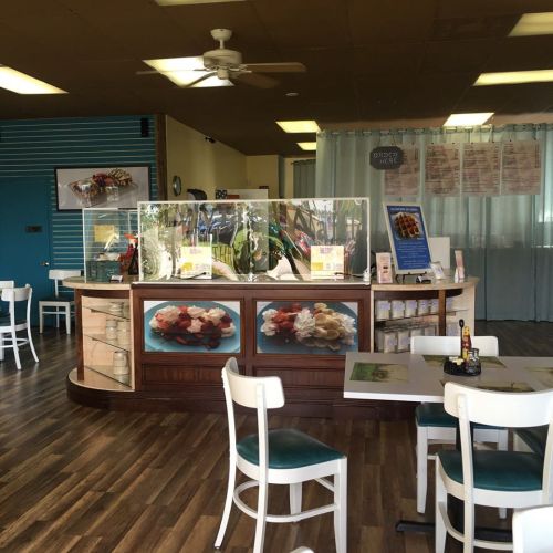 Bright interior of a dessert shop featuring a display counter, seating, and colorful decor.