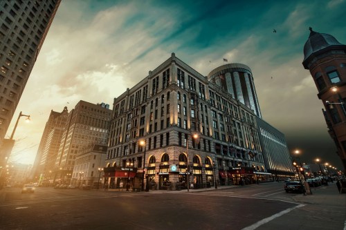 A city street scene featuring a historic building with modern skyscrapers under a dramatic sky.