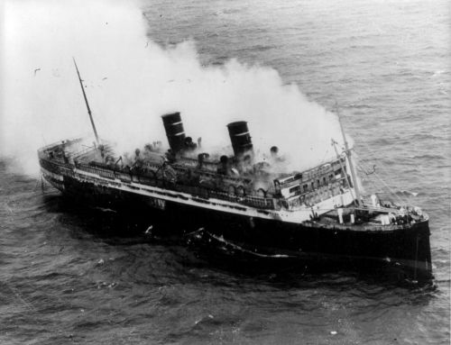 A historic black and white photo of a ship emitting smoke, appearing to be in distress at sea.