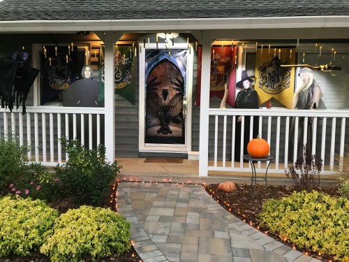 A decorated porch with house banners, Halloween decorations, and a pumpkin, creating a festive atmosphere.
