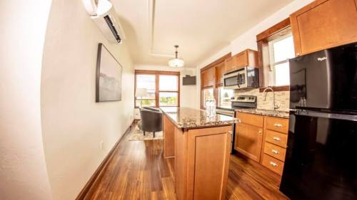 Modern kitchen with wooden cabinets, granite countertops, and stainless steel appliances, featuring a cozy dining area.
