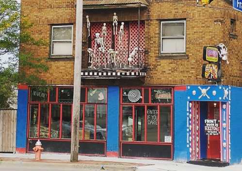 A quirky building with skeleton decorations, colorful blue and red walls, and a sign that says "Enter if you dare."