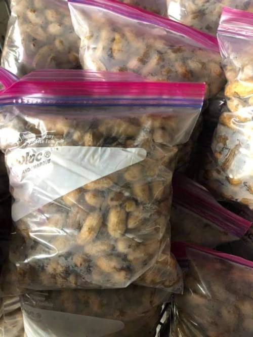 Several clear plastic bags filled with small, brownish items, stacked together.