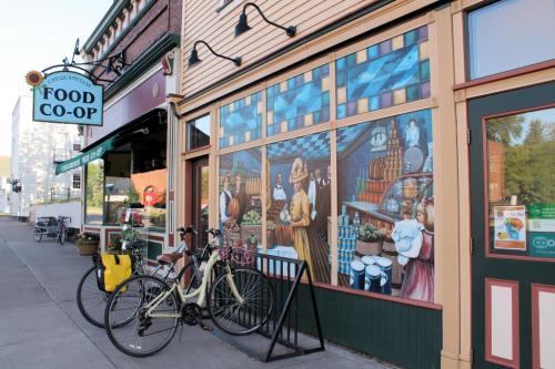 A colorful mural on a storefront with bicycles parked outside the Food Co-op.