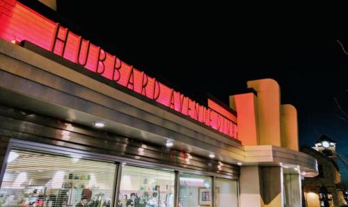 A brightly lit building at night with "Hubbard Avenue Diner" sign, showcasing a retro architectural style.