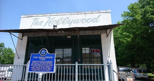 Exterior of The Hollywood Cafe with a sign indicating it's open, featuring a historical marker in front.