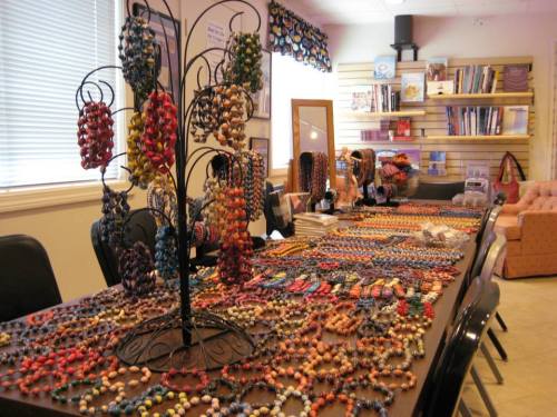 A display of colorful handmade jewelry on a table, with necklaces and bracelets arranged neatly.